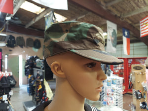 Mannequin head turned to side with woodland cover on it's head. Woodland being Dark Blue, green and light green branch like pattern of all three colors. The hat doesn't have back adjustment. 